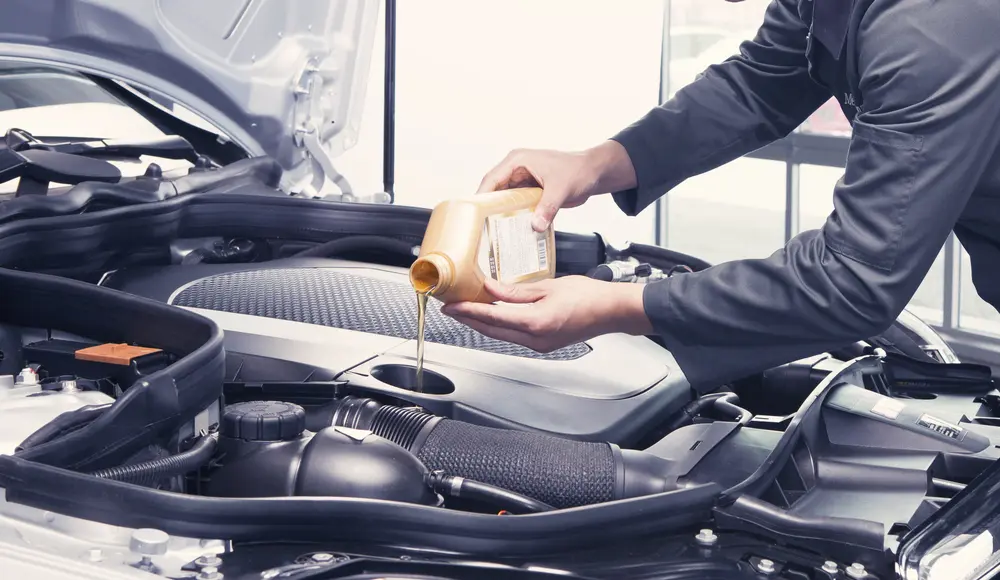 Mechanic,Pouring,Oil,Into,Car,At,The,Repair,Garage